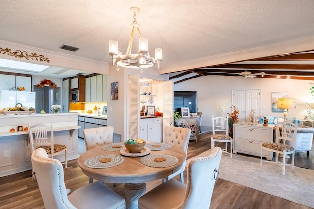 dining room with ceiling fan with notable chandelier, a textured ceiling, lofted ceiling with beams, and dark wood-type flooring