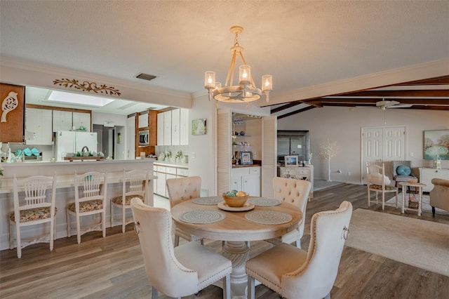 1433 Lake Marion Dr, Apopka, FL 32712 - dining room with vaulted ceiling, visible vents, light wood-type flooring, crown molding, and a notable chandelier