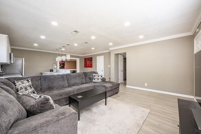 2803 E Pine St, Orlando, FL 32803 - living room with crown molding, baseboards, visible vents, light wood-style flooring, and indoor wet bar