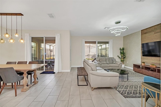 living room featuring light tile patterned flooring and an inviting chandelier