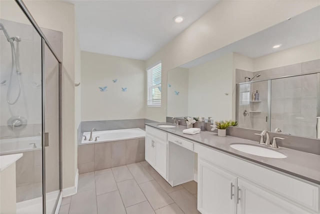 bathroom with tile patterned floors, vanity, and shower with separate bathtub