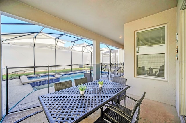 view of patio / terrace with a lanai and an in ground hot tub