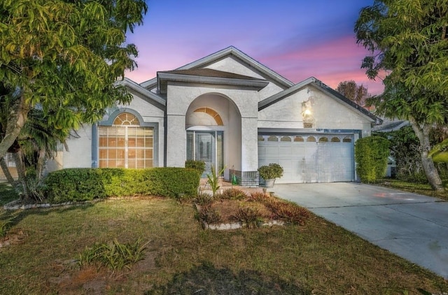 view of front of home with a yard and a garage