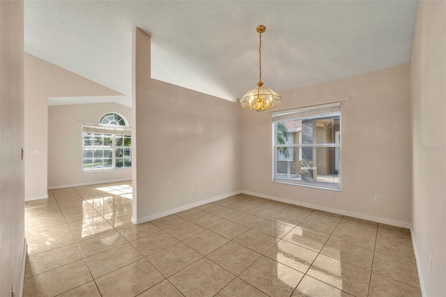 spare room with vaulted ceiling and an inviting chandelier