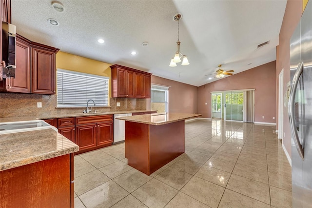 kitchen with ceiling fan with notable chandelier, pendant lighting, a center island, stainless steel appliances, and vaulted ceiling