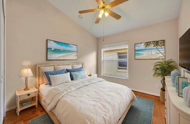 bedroom with ceiling fan, light hardwood / wood-style flooring, and lofted ceiling