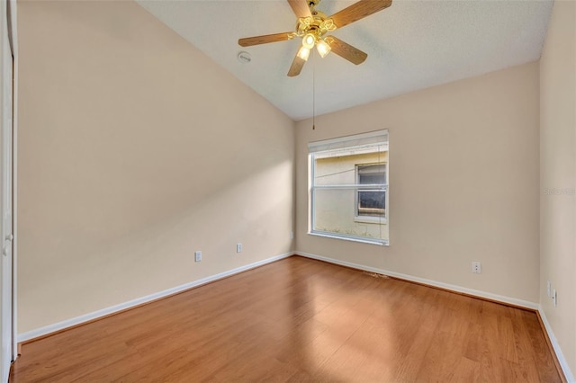 empty room featuring ceiling fan, wood-type flooring, and vaulted ceiling