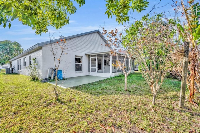 back of property with central AC, a sunroom, a lawn, and a patio