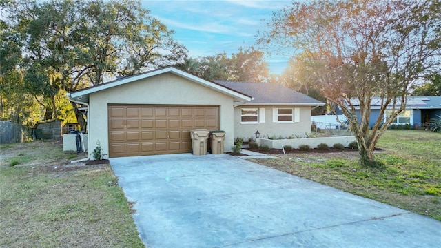 ranch-style home with a garage and a front lawn