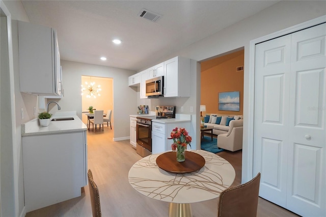 dining space featuring light wood-type flooring and sink