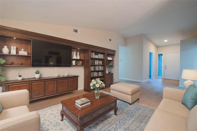 living room featuring vaulted ceiling and light wood-type flooring