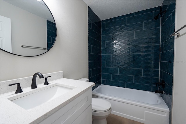 full bathroom with tiled shower / bath combo, toilet, a textured ceiling, and vanity