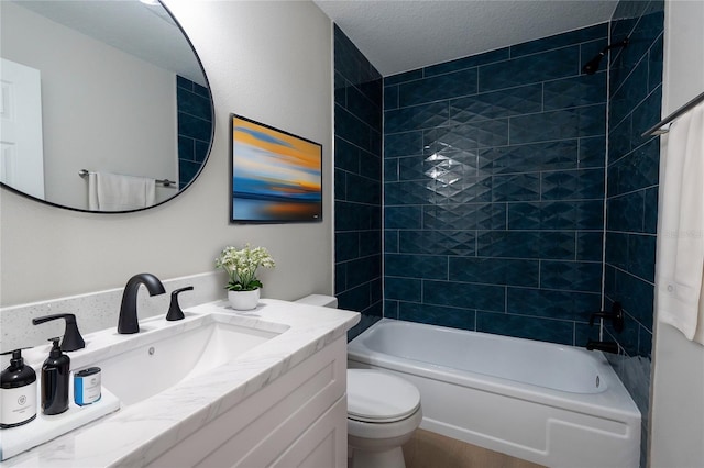 full bathroom featuring toilet, vanity, a textured ceiling, and tiled shower / bath