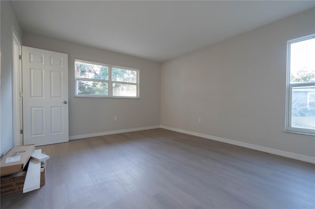 empty room with hardwood / wood-style floors and plenty of natural light