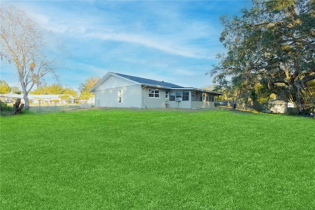 back of house featuring a lawn and a sunroom