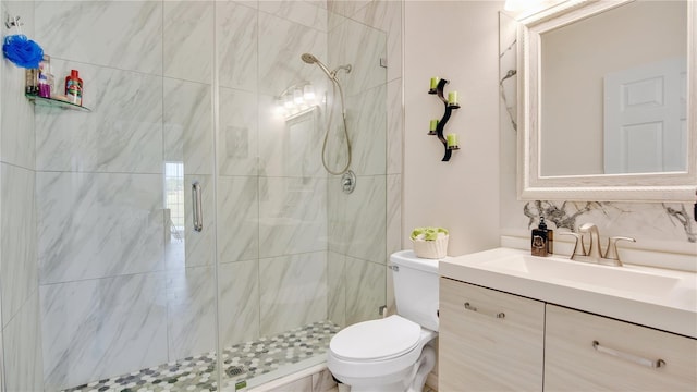 bathroom featuring vanity, toilet, a shower with shower door, and backsplash