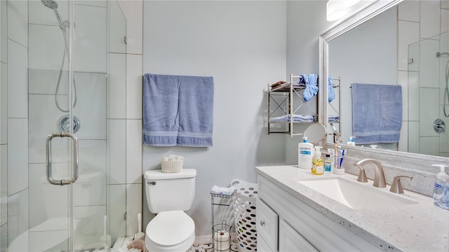 bathroom with vanity, toilet, and a shower with door