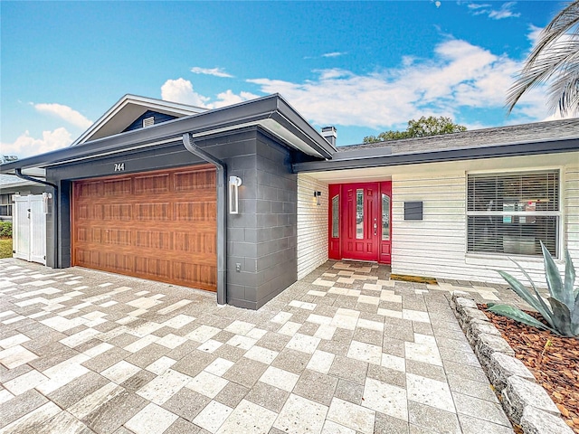 view of front of property featuring a garage and concrete block siding