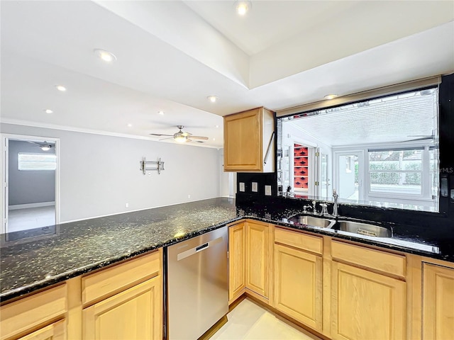 kitchen with dishwasher, dark stone counters, a sink, and a ceiling fan