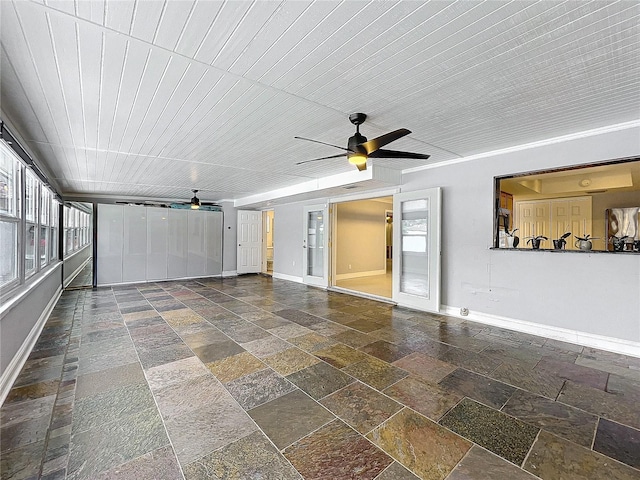 unfurnished sunroom with a ceiling fan