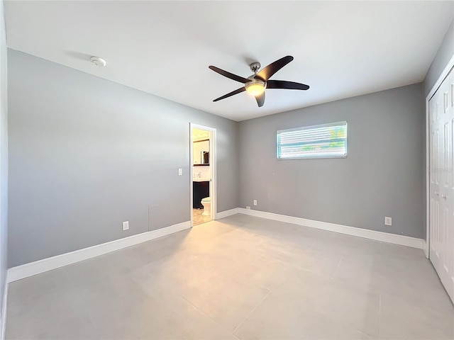 unfurnished bedroom with ensuite bathroom, ceiling fan, a closet, and baseboards