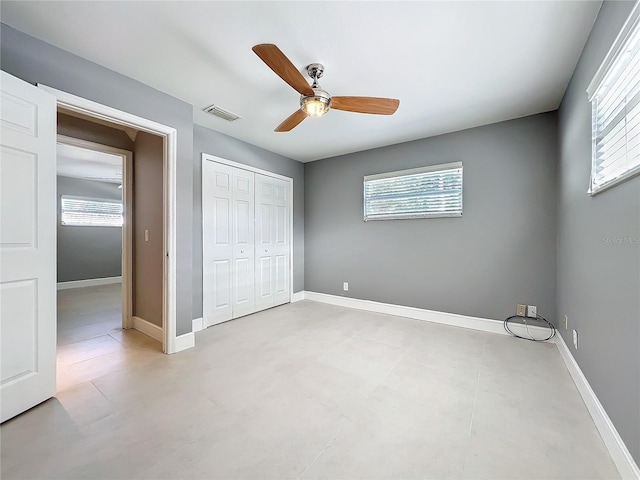 unfurnished bedroom featuring a ceiling fan, a closet, visible vents, and baseboards