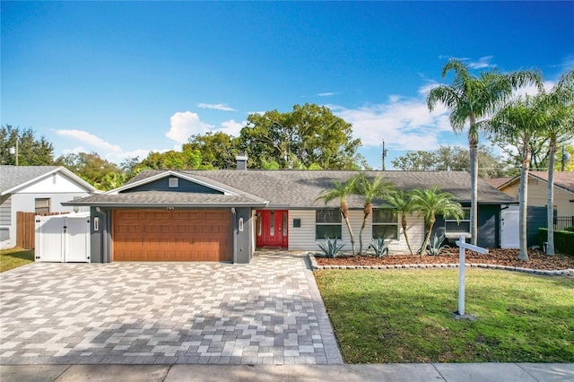 ranch-style home featuring a garage and a front yard