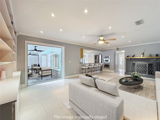 living room featuring recessed lighting, a brick fireplace, and crown molding