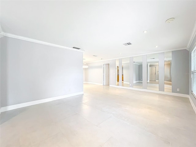 unfurnished room featuring ornamental molding, visible vents, and baseboards