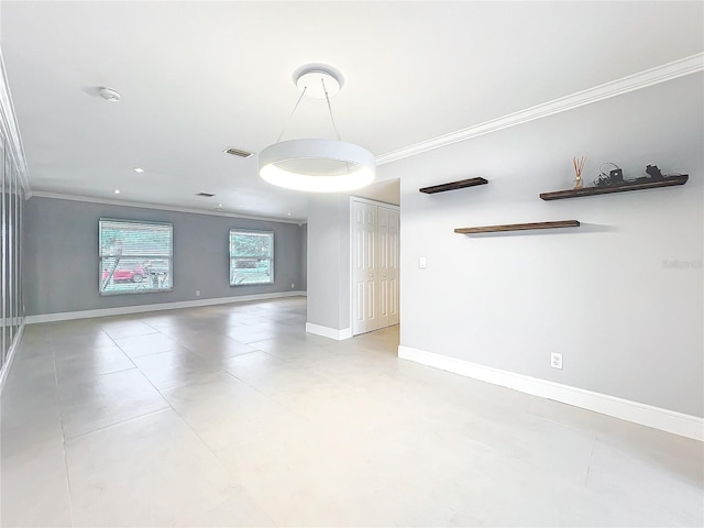 spare room with visible vents, baseboards, and crown molding