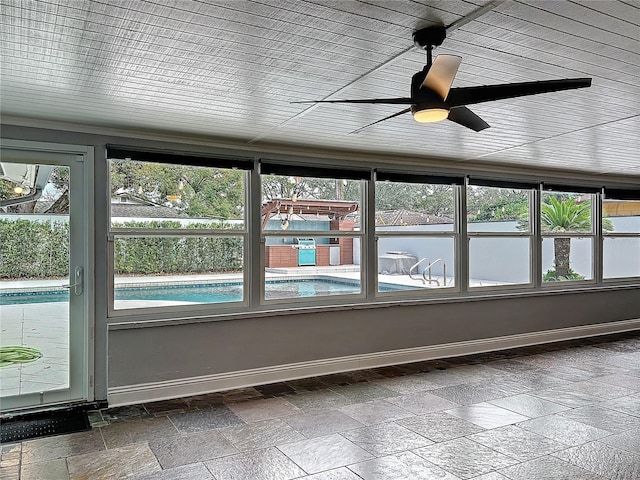 unfurnished sunroom with a ceiling fan