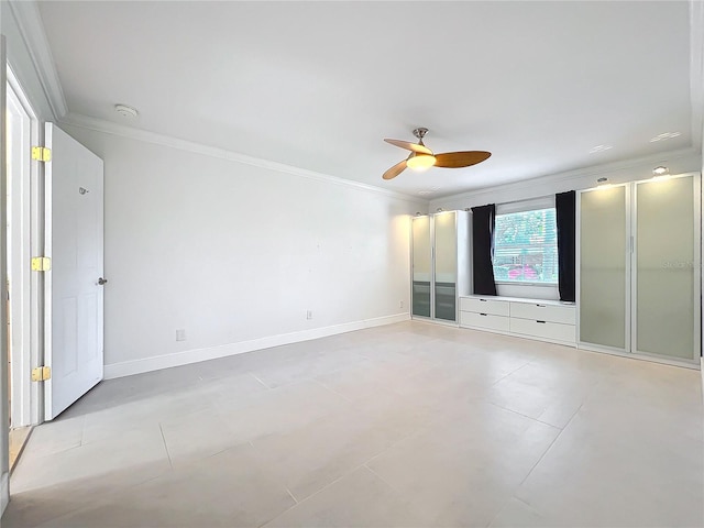 empty room featuring a ceiling fan, baseboards, and crown molding