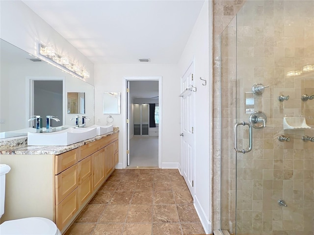 bathroom with a shower stall, visible vents, baseboards, and vanity