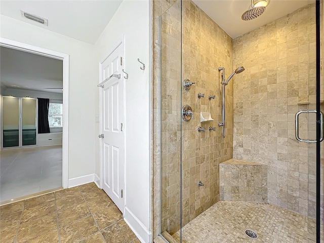 bathroom with a stall shower, visible vents, and baseboards