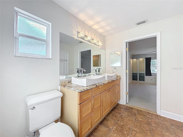 bathroom with baseboards, visible vents, a sink, and toilet