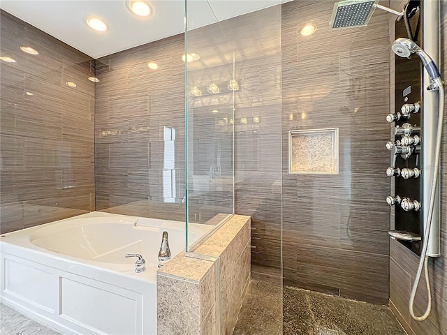 full bathroom featuring a garden tub, a walk in shower, and tile walls