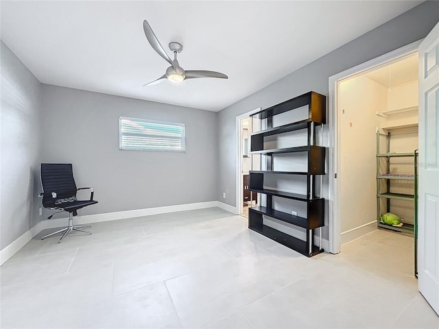 living area with baseboards and a ceiling fan