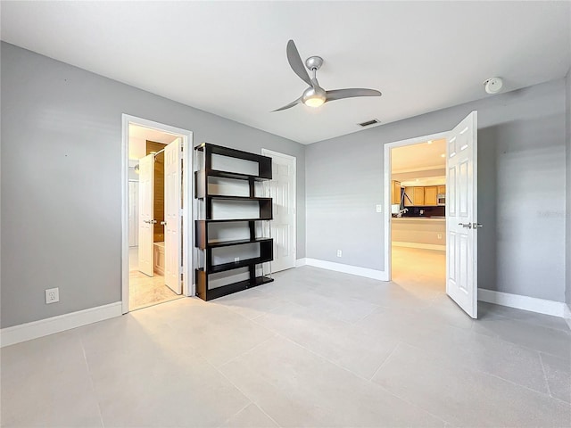 unfurnished bedroom featuring visible vents, ceiling fan, ensuite bath, and baseboards