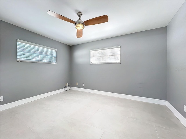 spare room with plenty of natural light, baseboards, and ceiling fan