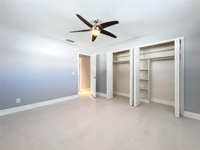 unfurnished bedroom featuring baseboards, a ceiling fan, visible vents, and multiple closets