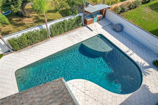 pool with a lawn and a patio area