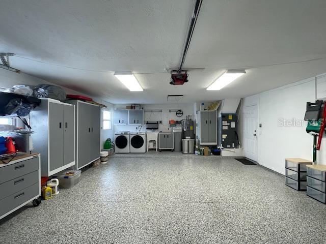 garage with washer and dryer and a garage door opener