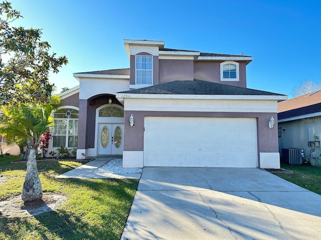 view of property with a front yard, central AC unit, and a garage