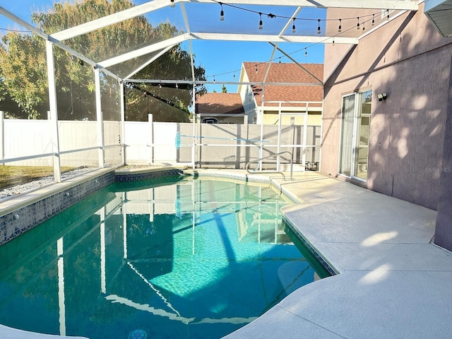 view of swimming pool with glass enclosure and a patio area