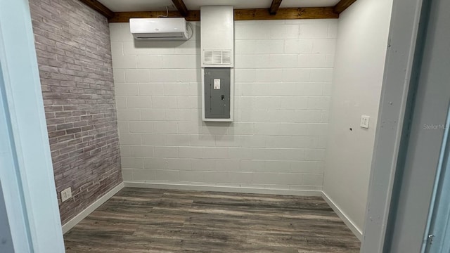 interior space with beam ceiling, dark wood-type flooring, a wall mounted air conditioner, brick wall, and electric panel