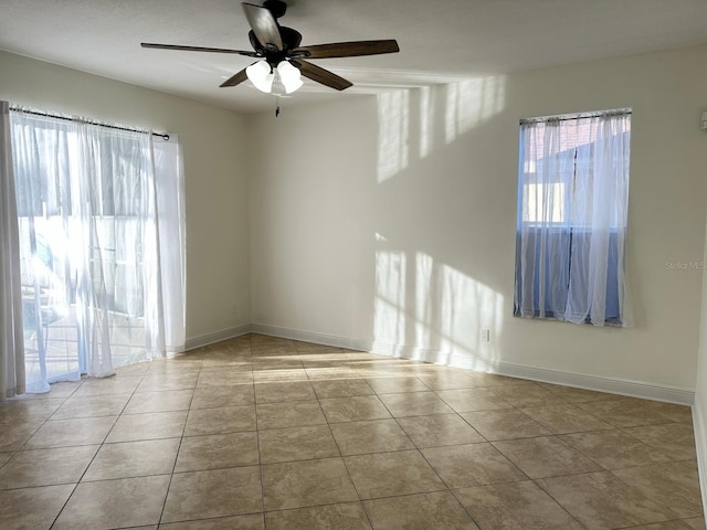 tiled spare room featuring ceiling fan