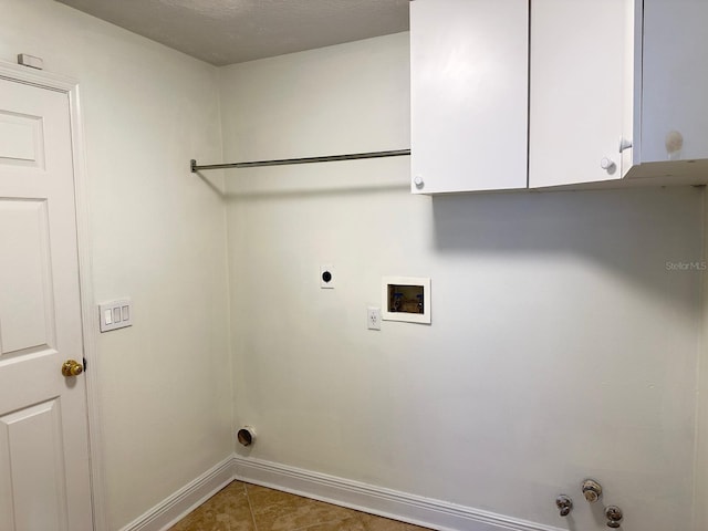 laundry room featuring gas dryer hookup, cabinets, dark tile patterned flooring, washer hookup, and hookup for an electric dryer