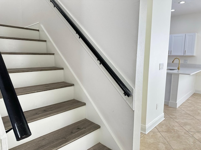 staircase with tile patterned floors and sink