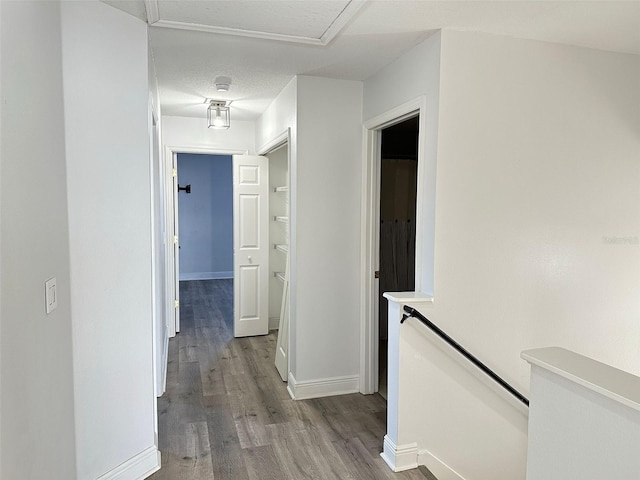 hall with light hardwood / wood-style flooring and a textured ceiling