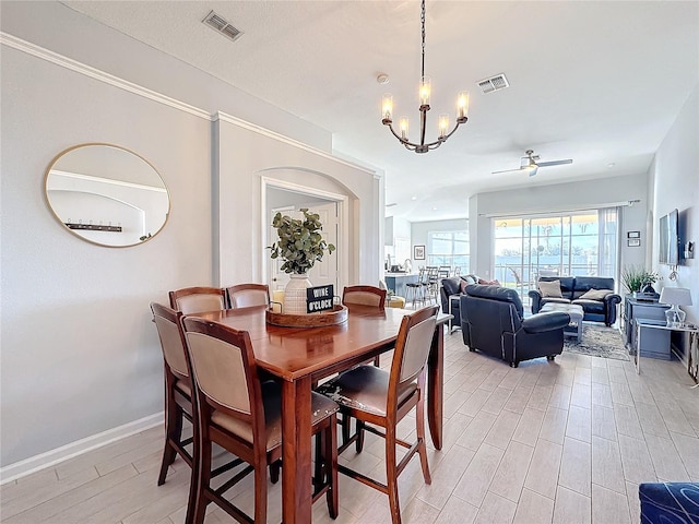 dining space featuring ceiling fan with notable chandelier